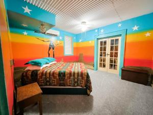 a bedroom with a bed with a colorful wall at Inn at the Art Center in San Angelo