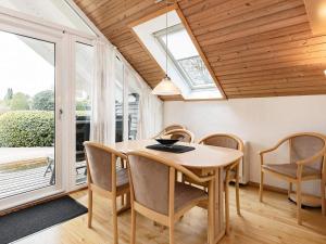 a dining room with a table and chairs and windows at 4 person holiday home in Idestrup in Marielyst