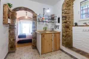 a kitchen with a sink and a room with a bed at La Esquinita in Tarifa