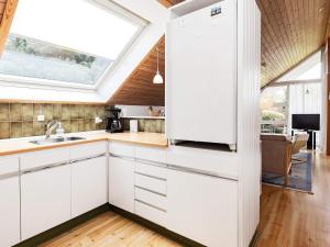 a kitchen with white cabinets and a window at 4 person holiday home in Idestrup in Marielyst