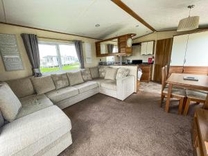 a living room with a couch and a table at Lovely Caravan With Decking At Millfields Caravan Park Ref 87025f in Skegness