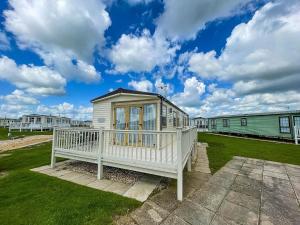 a small house with a porch in a yard at Lovely Caravan With Decking At Millfields Caravan Park Ref 87025f in Skegness
