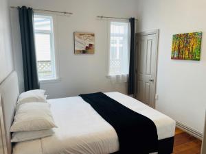 1 dormitorio con 1 cama con manta blanca y negra en Central Hut Villa, en Lower Hutt