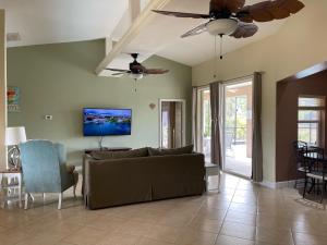 a living room with a couch and a ceiling fan at Pool Home in Englewood