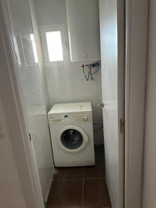 uma pequena casa de banho com uma máquina de lavar roupa e uma janela em El Gengo Hostel em Madri