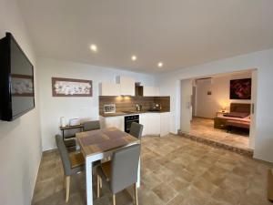 a kitchen and living room with a table and a dining room at Nice Place in Stanići