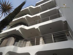 利馬的住宿－San Miguel Awanka Hotel，一座白色的建筑,前面有棕榈树