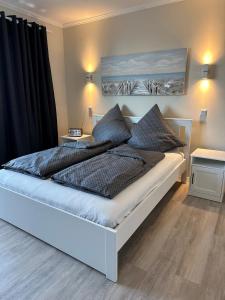 Schlafzimmer mit einem großen Bett und schwarzen Vorhängen in der Unterkunft Traumhafte Ferienwohnung "Seeperle" in Cuxhaven - Duhnen mit Teilseeblick in 1A Lage in Cuxhaven