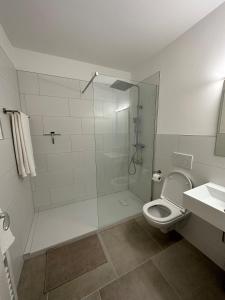 ein Bad mit einer Dusche, einem WC und einem Waschbecken in der Unterkunft Traumhafte Ferienwohnung "Seeperle" in Cuxhaven - Duhnen mit Teilseeblick in 1A Lage in Cuxhaven