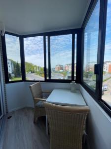 una mesa y sillas en una habitación con ventanas en Traumhafte Ferienwohnung "Seeperle" in Cuxhaven - Duhnen mit Teilseeblick in 1A Lage, en Cuxhaven
