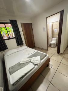 a bedroom with a bed and a bathroom with a toilet at Le Petit Hotel in Fortuna