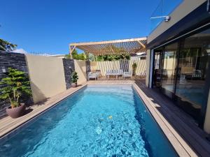 una piscina con terraza y una casa en Villa Jasmin Standing Piscine Chauffee 4 Ch 9 Pers, en Baie-Mahault 62 fotos más