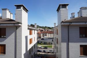 - une vue sur les toits des bâtiments d'une ville dans l'établissement ALMAR, Apartamento en Luanco., à Luanco