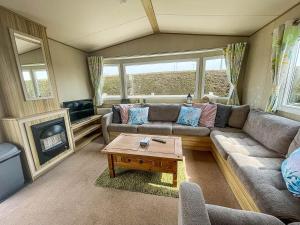 a living room with a couch and a coffee table at Caravan With Decking At Southview Holiday Park In Skegness Ref 33005s in Skegness