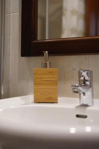 a bathroom sink with a wooden soap dispenser on it at ALMAR, Apartamento en Luanco. in Luanco