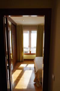 une chambre avec un lit et une fenêtre avec des rideaux dans l'établissement ALMAR, Apartamento en Luanco., à Luanco