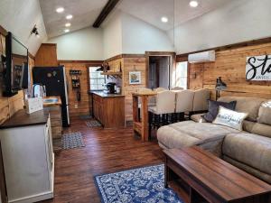 Hot Tub Private Cabin 5 min to College Station في Navasota: غرفة معيشة مع أريكة وطاولة ومطبخ