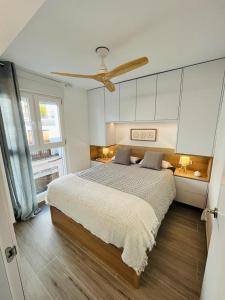 um quarto com uma cama e uma ventoinha de tecto em El Piset 124 em Benissa