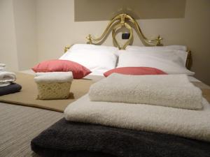 a bed with white pillows and red pillows on it at Suite Emilia in SantʼIlario dʼEnza