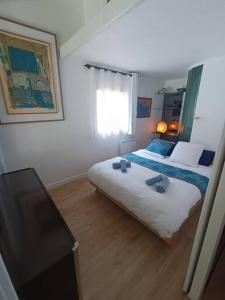 a bedroom with two beds and a flat screen tv at Chez Mamarina - Quadruplex - Marina Deauville in Deauville