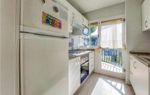 cocina con nevera, fregadero y ventana en Pet Friendly Apartment In El Portil With Wifi, en El Portil