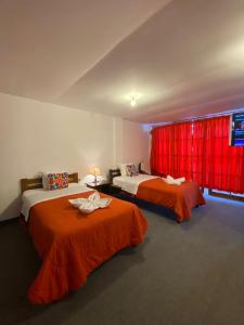 馬丘比丘的住宿－Paititi Classic，配有红色窗帘的客房内的两张床