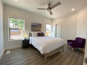a bedroom with a bed and a purple chair at Timber & Tin D 2Bed 2Bath w Pool & Rooftop Deck in Kanab