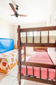 a bedroom with bunk beds and a ceiling fan at Pe na Areia Ótimo Apto Vista Mar in Praia Grande