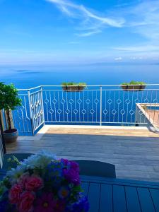 einen Balkon mit einem blauen Geländer mit Blumen darauf in der Unterkunft Blue Jolie in Scilla