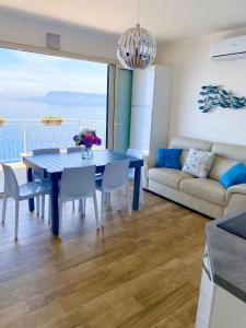 ein Wohnzimmer mit einem Tisch und einem Sofa in der Unterkunft Blue Jolie in Scilla