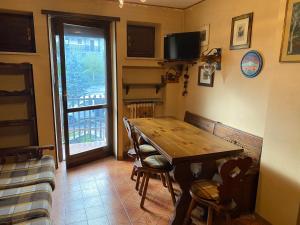 uma sala de jantar com uma mesa de madeira e cadeiras em BLU Appartament em Montoso