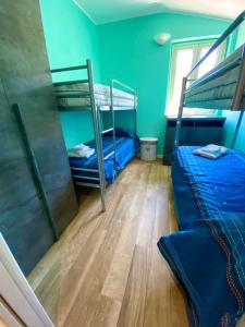 Zimmer mit 2 Etagenbetten und Holzboden in der Unterkunft Blue Jolie in Scilla