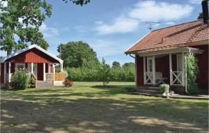 une petite maison avec une terrasse couverte à côté d'une cour dans l'établissement Awesome Home In Lttorp With Kitchen, à Löttorp