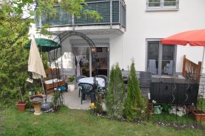 eine Terrasse mit einem Tisch und einem Sonnenschirm auf einem Haus in der Unterkunft TerraceOasisBerlinAirport in Schönefeld