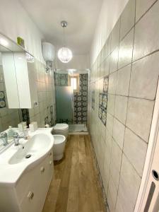 ein Badezimmer mit einem Waschbecken, einem WC und einem Spiegel in der Unterkunft Blue Jolie in Scilla