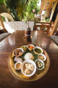 a plate of food on a wooden table with food at Netuk House a heritage boutique stay in Gangtok