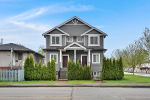 a gray house with bushes in front of a street at Family-Friendly, 3 Bed House - Private Backyard-Central Location in Vancouver