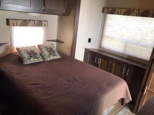 1 dormitorio con 1 cama con 2 almohadas y ventana en Orchard Queen Motel & Rv Park, en Middleton