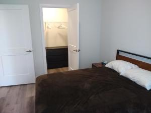a bedroom with a bed and a closet at Comfy Condo Near Downtown in Kitchener