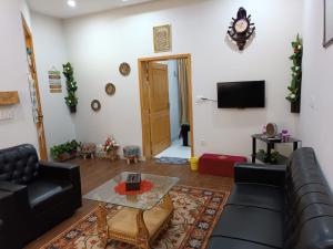 ein Wohnzimmer mit einem Sofa und einem Tisch in der Unterkunft Islamabad Comfort Home in Islamabad