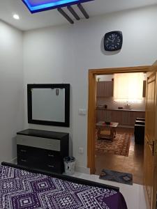 a living room with a flat screen tv on the wall at Islamabad Comfort Home in Islamabad