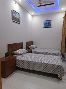 a bedroom with two beds and a blue ceiling at Islamabad Comfort Home in Islamabad