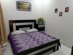 a bedroom with a bed with a purple comforter at Islamabad Comfort Home in Islamabad