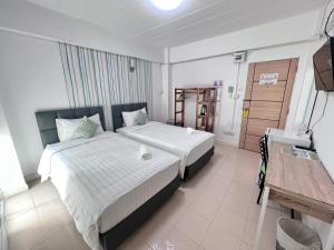 a hotel room with two beds and a television at Malizon Hotel and Residences in Nonthaburi