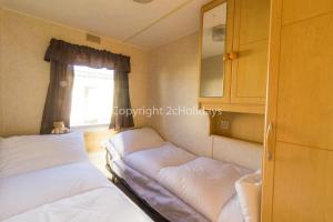 - une petite chambre avec 2 lits et une fenêtre dans l'établissement Great 6 Berth Caravan For Hire At Sunnydale Holiday Park In Skegness Ref 35150tm, à Louth