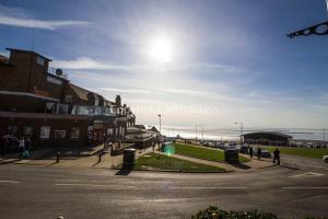 a street in a town with the ocean in the background at Superb Caravan With Decking Close To Hunstanton Beach In Norfolk Ref 23060s in Hunstanton