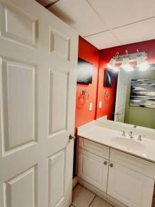 La salle de bains est pourvue d'un lavabo blanc et d'un miroir. dans l'établissement Your Ultimate Beachfront retreat! Brand New Flooring!!, à Panama City Beach