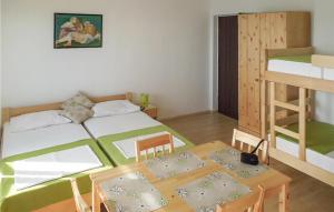 a bedroom with a bed and a table and a bunk bed at Pet Friendly Apartment In Martinscica With Kitchen in Martinšćica