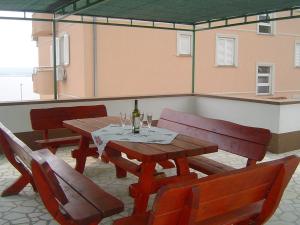 uma mesa de madeira com cadeiras e uma garrafa de vinho em Apartment in Dramalj with sea view, balcony, air conditioning, WiFi 4623-6 em Dramalj