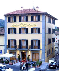 un gran edificio con gente parada frente a él en Hotel Antico Masetto, en Lamporecchio